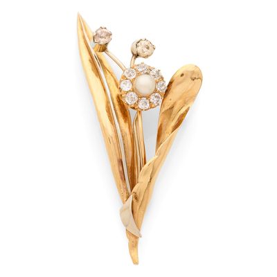 un gros plan d'une broche en forme de fleur avec une perle au centre