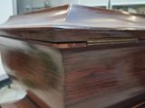 a wooden casket sitting on top of a wooden table