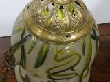 a white vase with a gold lid on a wooden table