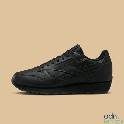 une basket en cuir noir avec une semelle noire et des lacets noirs