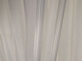 a close up of a white curtain with a black cat on it