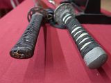 two swords on a red table with a red table cloth