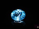 a close up of a blue diamond on a black surface