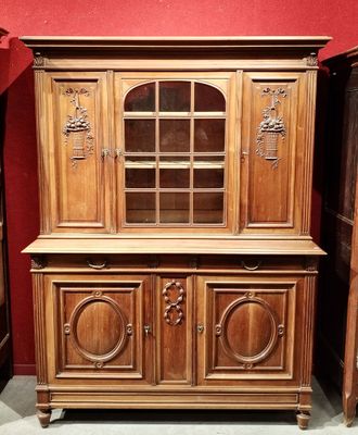 un vaisselier en bois surmonté d'une porte vitrée