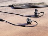 a cell phone and earphones on the ground next to each other