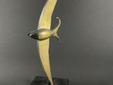 une sculpture en bronze représentant un oiseau, posée sur un socle en marbre