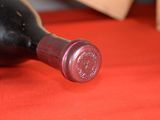 a bottle of wine sitting on a red table cloth