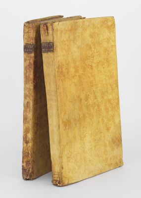 un vieux livre posé sur une table à côté d'un autre livre