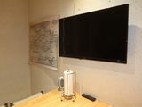 a flat screen tv mounted on a wall above a desk