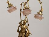 une statue en or représentant un homme tenant une lampe