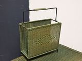 a wicker basket on the floor next to a black door
