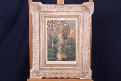 une peinture à l'huile représentant une rivière dans un cadre boisé, posée sur un chevalet en bois