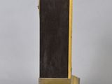 an antique brass clock with a black dial and a brown leather band