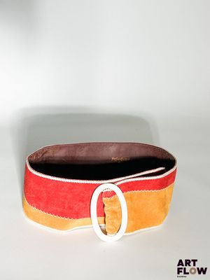 une ceinture munie d'une boucle, posée sur une surface blanche