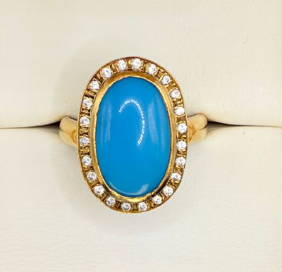a close up of a gold ring with a blue stone and diamonds