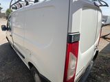 the back end of a white van parked in a field