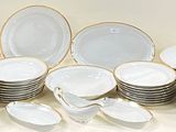 a lot of white and gold plates on the table