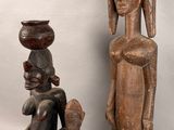 two wooden sculptures of a woman and a child, one of which is holding a bowl