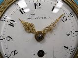 a blue and gold clock with a bird on top of it