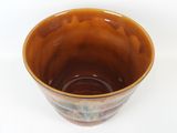 a close up of a brown bowl on a white surface