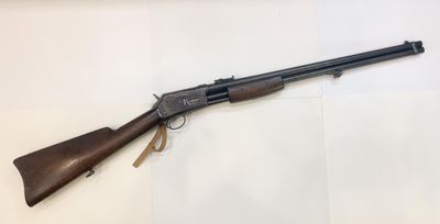 a rifle with a wooden barrel on a white surface