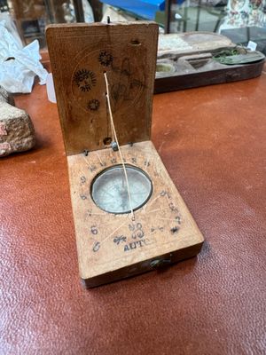 a wooden box with a compass on it on a table