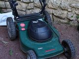 two lawn mowers sitting next to each other on the ground