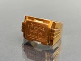 a gold ring with a picture on it on a table
