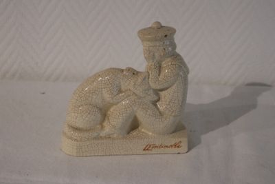 une figurine représentant un homme et un chien sur un fond blanc