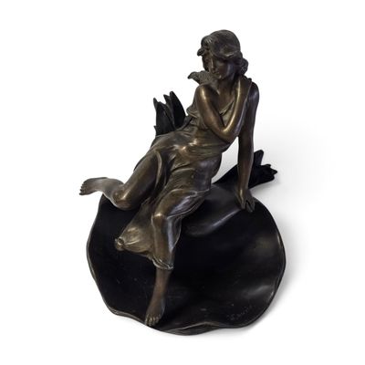 statue en bronze représentant une femme assise sur une feuille, tenant un oiseau