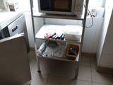 un micro-ondes posé sur une étagère dans une cuisine, près d'une fenêtre