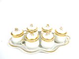 a tray with five white and gold teapots on it