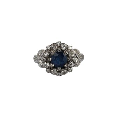 gros plan d'une bague avec une pierre bleue entourée de diamants blancs