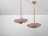 une paire de lampes en verre rose suspendues au plafond