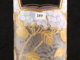 a glass vase with a gold and white design on it