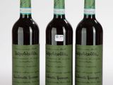 trois bouteilles de vin posées les unes à côté des autres sur une surface blanche