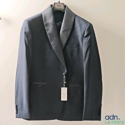 a suit hanging on a hanger on a wall