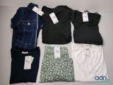 quatre paires de vêtements pour homme disposées sur une table