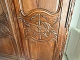 une armoire en bois avec des sculptures dans une pièce