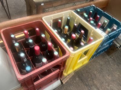 les bouteilles de vin sont empilées les unes sur les autres dans des caisses