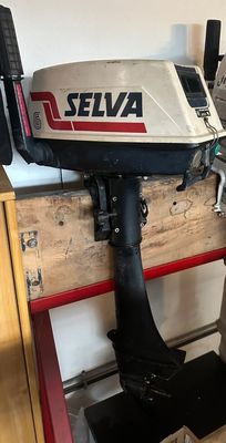 two outboard motors sitting on a pallet in a garage