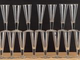 six clear wine glasses sitting on top of a wooden table