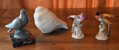 three figurines of birds sitting on a wooden table