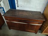 a wooden cabinet with a drawer underneath it in a room