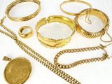 beaucoup de bracelets et de bagues en or posés sur une table