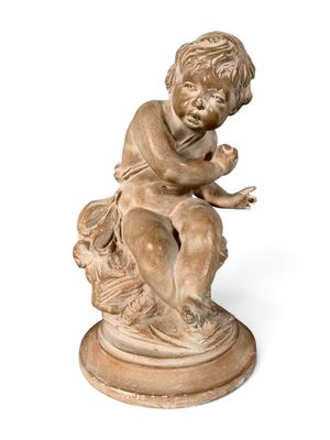 a small statue of a boy sitting on a pedestal
