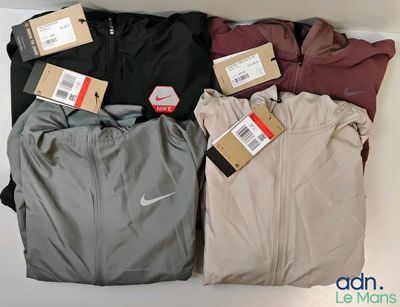 several pairs of men ' s nike tracksuits are on display in a box