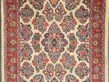 an antique persian rug with a floral design on a beige ground
