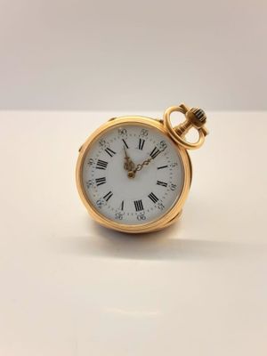 Gros plan sur une montre de poche en or avec des chiffres romains