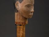 a wooden sculpture of a woman ' s head on a stand